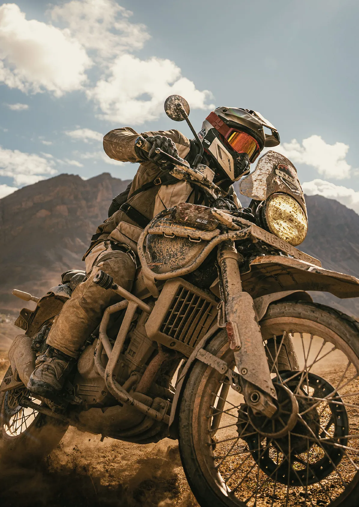 Moto de aventura cubierta de barro en un puerto de montaña